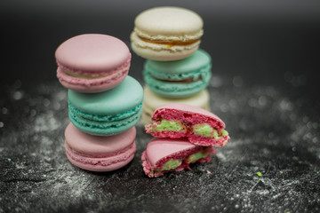 colored macaroons on a black background