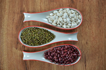 different types of beans in spoons