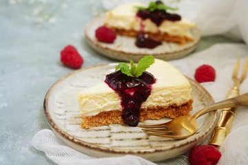 Slice of Hmemade Cheesecake with raspberry blueberry sauce, selective focus