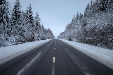 Fototapeta premium Winter road through forest