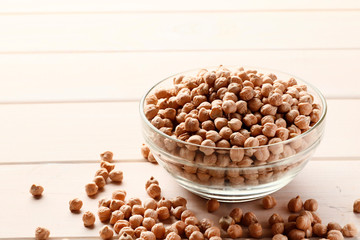 Chickpeas in a bowl on a white wooden background