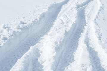 Fototapeta na wymiar Fresh snow background texture. Winter background with snowflakes and snow mounds. Snow lumps. Road track and traces.