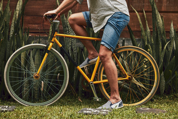 Attractive man standing with old bicycle.