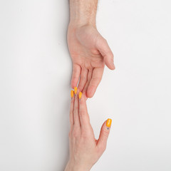 Female and male hands on a light background.