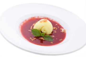 The best summer dish - fresh lemon sorbet in strawberry sauce with a mint leaf. Close up izolated on white background.