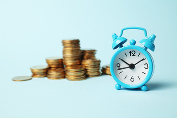 Time is money concept. Alarm clock and golden coins. Financial option of cash investment.