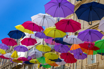 Colourful sun umbrellas against the blue sky. Street decoration. Copy space.