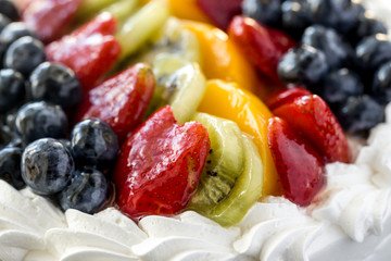Assorted glazed fruits on a cake.
