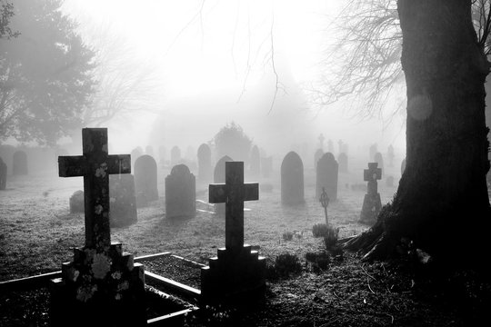 black and white photograph of an English grave yard covered in thick fog