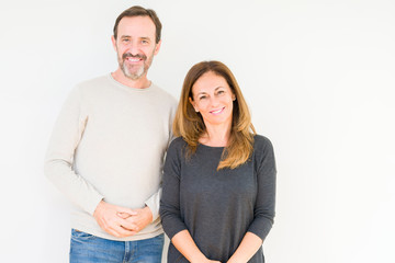 Fototapeta premium Beautiful middle age couple in love over isolated background Hands together and fingers crossed smiling relaxed and cheerful. Success and optimistic