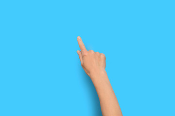 Female hand touches finger a blue background. Flat lay, top view