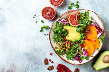 Vegan, detox Buddha bowl with turmeric roasted  chickpeas, greens, avocado, persimmon, blood...