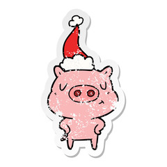 distressed sticker cartoon of a content pig wearing santa hat