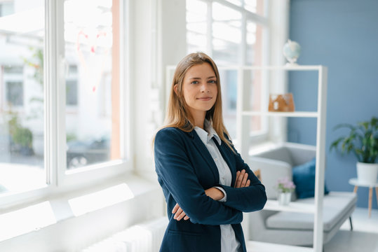 Portrait Of A Confident Young Businesswoman, Standing In Office