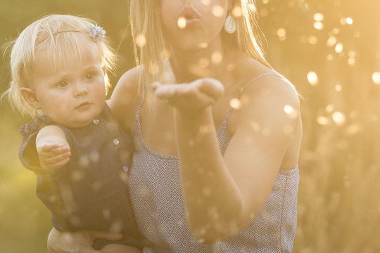 Mother and daughter blowing glitter