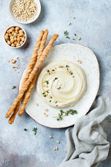 Homemade hummus with thyme, olive oil and pine nuts with grissini bread sticks. Middle Eastern...