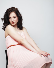 Fototapeta premium young woman with curly hair wearing pink dress