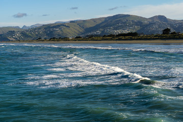 aerial view of the sea, calm waves and mountain range on the horizon