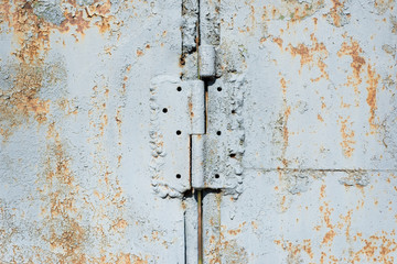 Old iron wall with door hinge covered by white paint. Abstract background.