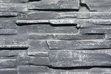 The wall textured as wild stone covered with gray paint. For design, banner and layout
