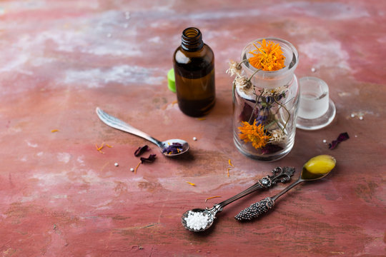 Blossoms of medical plants, medicine flasks, marigold salve and globules