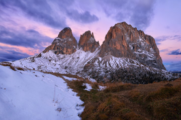 Italy, Alto Adige, Dolomites, Sassolungo, Fuenffingerspitze and Grohmannspitze at sunrise twilight, late autumn with first snow