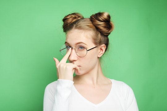 Studio shot of good looking female, doesn`t have much experience, wears big round spectacle.