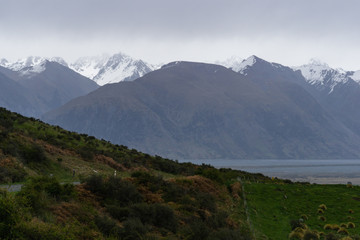 foggy landscape in the mountains, brown hills and peaks covered by snow