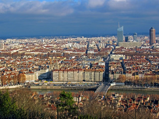 Aerial view of the city wide panorama with landmarks surrounded by red rooftops and chimneys, Lyon, France