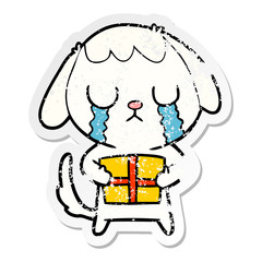 distressed sticker of a cute cartoon dog with christmas present
