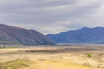 mountain landscape in the mountains, beautiful vast valley with mountains on the horizon, peaks in distance, during sunny with dramatic sky