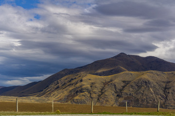 Shadow play on steep brown hills during warm but cloudy day