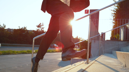 CLOSE UP: Young businessman running late to his office on a sunny morning.