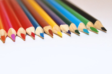 Colored wooden pencils on a white background. Twelve pieces. Close-up. Texture.