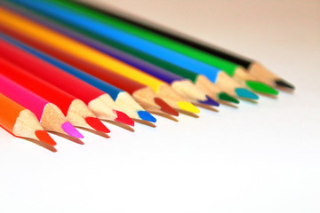 Colored wooden pencils on a white background. Twelve pieces. Close-up. Texture.