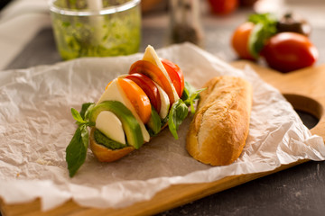 vegetarian italian food caprese sandwich with avocado cheese and pesto sauce