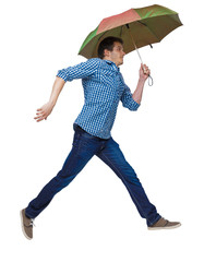 Side view of a man balancing with an umbrella.