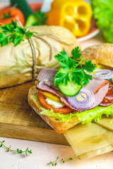 Sandwich with ham, tomato, cheese, pepper, onion and salad