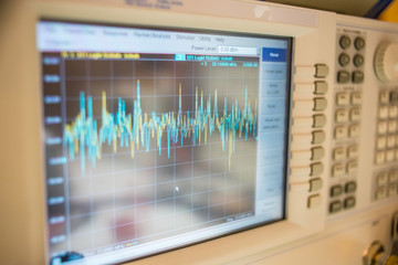 closeup view of oscilloscope with graph on lcd display and connected cords