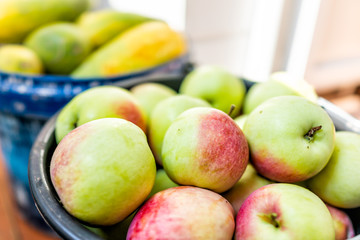 Closeup of large buckets basket filled with fresh green red garden orchard apples and cucumbers fruit after harvest