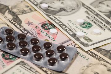 Fototapeta premium High Angle View on Dollars and medicine painkiller pills Health Costs