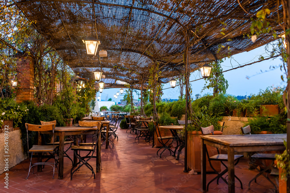 Wall mural typical italian rooftop restaurant wooden tables in tuscany with covered roof pergola vine canopy wi