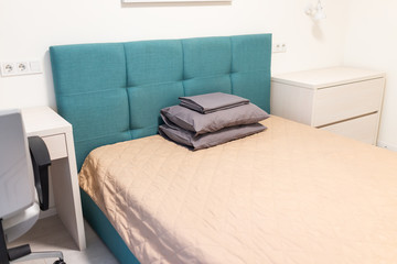 Minimalism bed with green blue headboard office table desk chair in bedroom of home, house or apartment in hotel