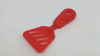 red plastic toy spatula