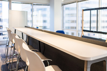 Modern empty office room lunch kitchen bar in building with wooden corporate business table closeup by glass window and many row chairs nobody