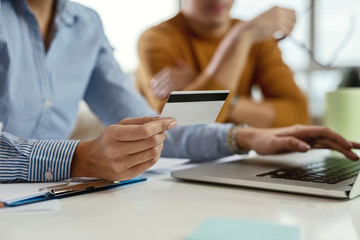 Close up of businesswoman using credit card for online shopping.