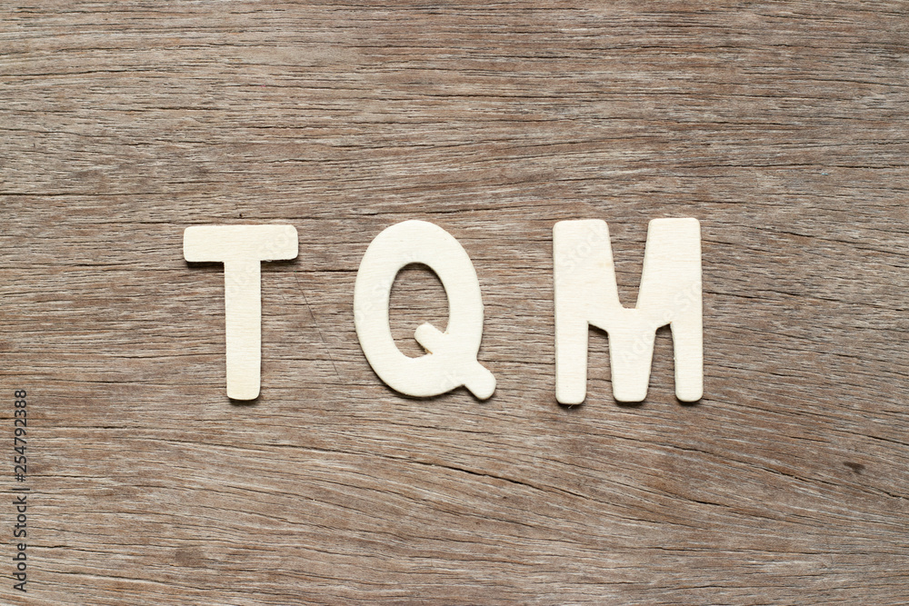 Poster Alphabet letter in word TQM (Abbreviation of total quality management) on wood background