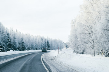 Obraz na płótnie Canvas Landscape of car at road in snowy winter Lapland