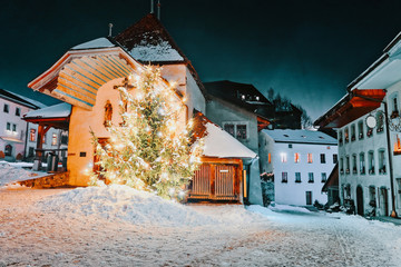 Night view of illuminated Christmas fir tree street of Gruyeres