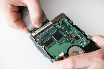 Hard disk recovery service, hands of repairman holding broken hdd with bad sectors. Computer...